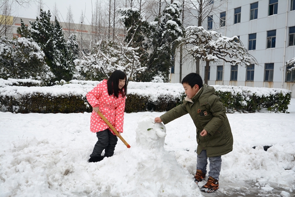 美丽的景色吸引孩子们前来堆雪人