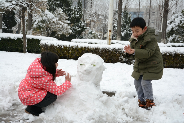 美丽的景色吸引孩子们前来堆雪人